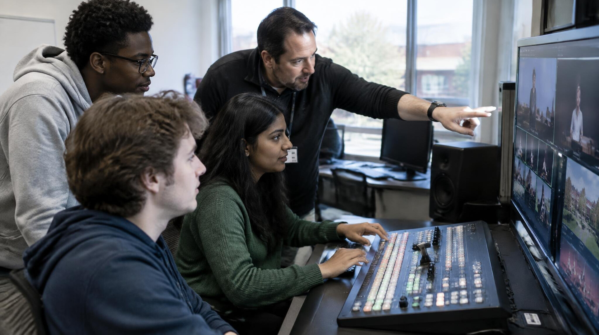 Students training at a video mixing console during a broadcast production course